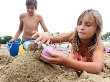 Jana Mikolagewski, 8, and her brother Andrew work on sand castles at Fish Creek Park's Sikome lake in Calgary on August 17, 2015.