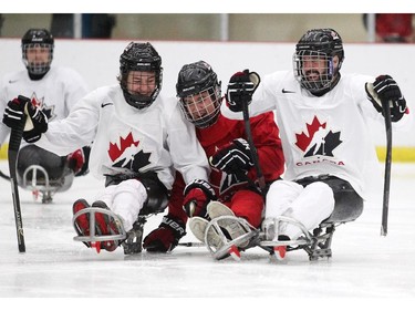 Forwards Corbyn Smith, left, and Greg Westlake, right, sandwiched forward Coalton Martin during the afternoon training session for the Canadian National Sledge Team development camp at Winsport on August 24, 2015. Westlake had an off-season job commentating and reporting at the Pan-American Games.