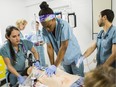 Simi Fagbongbe works on a "patient" during a CPR simulation during a challenge in Sudbury, Ont. on The Amazing Race Canada.