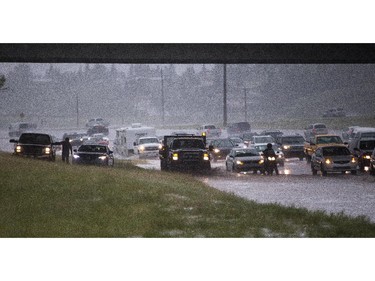 Motorists take to the 16th Avenue underpass to avoid heavy hail and rain on Deerfoot Trail in Calgary on Tuesday, Aug. 4, 2015.