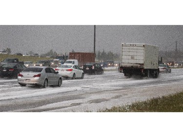 Mounds of hail pile up on Deerfoot Trail after an extreme bout of weather in Calgary on Tuesday, Aug. 4, 2015.