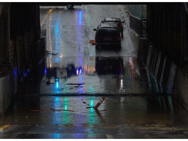 The 9th Avenue and 1st Street SW underpass is flooded, with a pair of vehicles abandoned in downtown Calgary on Tuesday, Aug. 4, 2015.