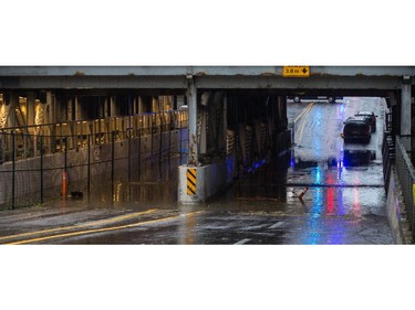 The 9th Avenue and 1st Street SW underpass is flooded, with a pair of vehicles abandoned in downtown Calgary.