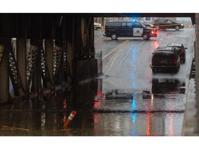 The 9th Avenue and 1st Street SW underpass is flooded, with a pair of vehicles abandoned in downtown Calgary on Tuesday, Aug. 4, 2015.