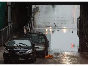 The 9th Avenue and 1st Street SW underpass is flooded, with a pair of vehicles abandoned in downtown Calgary on Tuesday, Aug. 4, 2015.