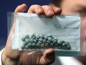 Calgary Police Service Staff Sgt. Martin Schiavetta, of the CPS Drug Unit, holds an evidence bag with seized Fentanyl tablets.