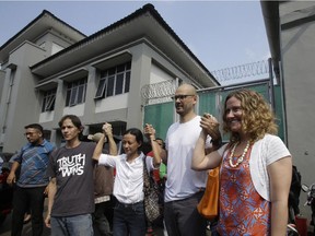 Canadian teacher Neil Bantleman, second right, holds hands with his wife Tracy Bantleman, right,  Indonesian teaching assistant Ferdinant Tjiong, left, and his wife Sisca Tjiong, center, as they pose for photographers after the teachers were released from Cipinang prison in Jakarta, Indonesia, Friday,Aug.14, 2015. A Canadian teacher and an Indonesian teaching assistant serving 10 years in an Indonesian prison for child sexual offenses were released Friday after a court overturned their convictions.