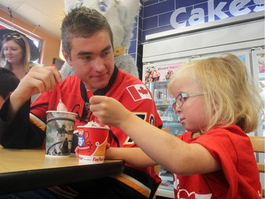 Calgary Flames left winger Micheal Ferland was on hand to help with the 13th Annual Miracle Treat Day at Dairy Queen to support the Alberta Childrens Hosipital. During the event, he even had time to enjoy a Blizzard with Childrens Hospital Ambassador four-year-old Violet McDonald on August 13, 2015.
