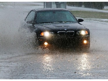 Cars drive down a flooded 19th street N.E. after a fast moving hail storm moved through Calgary Tuesday afternoon.
