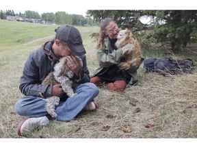 Homeless couple Lee Myshak, left, holding Shilo, a pomerian shitzu, and Lea Mayan with Jake, a minature pom, in a NE park Friday June 12, 2015.