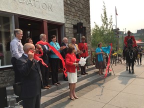 Lois Mitchell, lieutenant-governor of Alberta, cuts the ribbon for the Banff Canmore Community Foundation in Banff on Aug. 26, 2015, as other dignitaries look on.