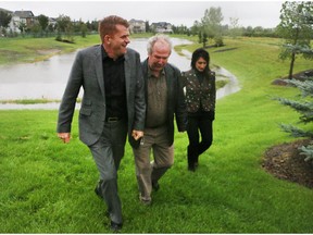 Wildrose leader Brian Jean speaks with Rocky View councillor Rolly Ashdown at a low area that flooded in July during a flood tour of the town with local MLA Leela Aheer, right, Friday August 21, 2015. (Ted Rhodes/Calgary Herald)