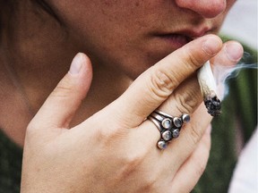A member of the Niagara Cannabis Club smokes pot infront of the courthouse on July 1, 2015, in St. Catharines. For the fifth year the group has lit up to bring awareness of medicinal marijuana. Bob Tymczyszyn/St. Catharines Standard/Postmedia Network