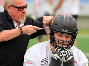 Calgary Stampeders equipment manager George Hopkins makes an adjustment to offensive lineman Shane Bergman's helmet before practice on Thursday. The Stamps are carrying a solid track record in close games into their match in Winnipeg on Saturday.
