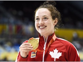 Morgan Bird of Calgary shows off her gold medal after winning the women's S8 400m and the women's S8 50m during the Parapan Am Games in Toronto on Sunday.