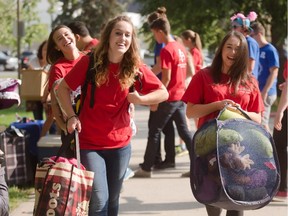 Members of U of C Community Advisors group bring bags and luggage into Rundle Hall during Move-in day at the University of Calgary in Calgary on Sunday, Aug. 30, 2015.