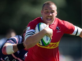 Calgary's Nick Blevins fights off The United States' Blaine Scully, back, to score a try during the second half of the Pacific Nations Cup fifth place rugby match in Burnaby, B.C., on Aug. 3.