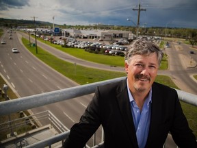 Nick Twyman, president of Sunalta Community association, stands on the pedestrian overpass leading to the site of where a new Calgary Flames arena could be placed.