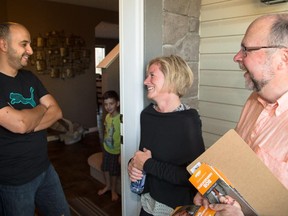 Fadi, left, meets with Alberta Premiere Rachel Notley and Bob Hawkesworth, the NDP candidate for Calgary-Foothills, during door knocking in the community of Kincora in Calgary on Wednesday, Aug. 19, 2015.