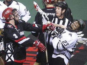 Roughnecks defenceman Dan MacRae, left, battles Edmonton's Jarrett Davis during a National Lacrosse League game last May. MacRae has re-signed with the team.