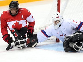 Canada's Brad Bowden scores on Norway goalie Kristian Buen during the bronze medal sledge game at the 2014 Winter Paralympics in Sochi, Russia on March 15, 2014.