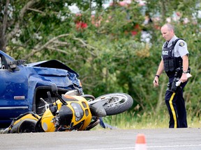 An RCMP officer assesses the scene after a crash north of Cochrane.