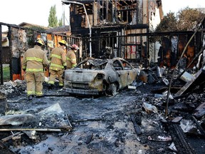 Firefighters investigate the scene of a house fire at Templevale Drive NE Calgary on August 13, 2015.