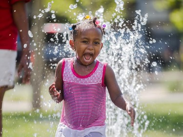 Wongel, 3, enjoys an afternoon of running through fountains at Central Memorial Park to avoid the hot weather in Calgary on Thursday, Aug. 13, 2015.
