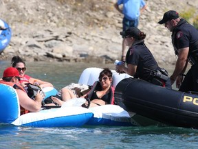 Calgary Police Service river patrol unit sweeps the Bow River near the Harry Boothman Bridge for rafters not wearing personal floatation devices and consuming alcohol or other illegal substances Sunday afternoon. This group of rafters had their beer confiscated.