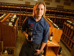 Peter Smolarz shows off some bottles of fine wine at the Willow Park Wine and Spirits in Calgary on Wednesday, Aug. 26, 2015. Smolarz had been chosen to represent Canada in the La Chaine des Rotisseurs International Jeunes Sommeliers Competition to be held in Adelaide, Australia.