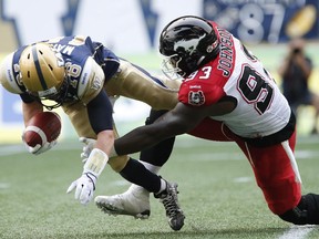 Winnipeg Blue Bombers quarterback Robert Marve (16) gets sacked by Calgary Stampeders' Micah Johnson (93) during the first half of CFL action in Winnipeg Saturday, August 29, 2015.
