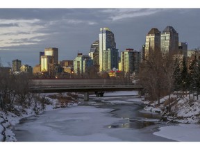 A sunset view of the Calgary downtown skyline, as the c-train crosses a bridge over the Elbow River, in Calgary,