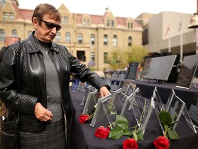 Eleanor Badry, whose firefighter husband died in 2013,  places a rose on her husband's memorial during the Memorial March that ended in a ceremony at the Police Officers and Firefighters Tribute Plaza in front of City Hall.