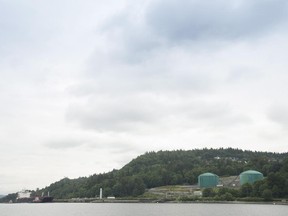 A tug boat helps guide a tanker away from the docks at the Kinder Morgan Trans Mountain Expansion Project in Burnaby, British Columbia, Thursday, June 4, 2015.