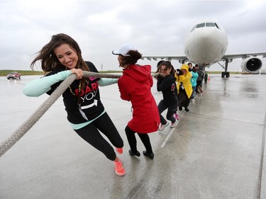 Sarah Foreman, left, and the rest of her Team United Way, pull a 200,000 lb Airbus A300 during the fourth annual Plane Pull event put on by United Way Calgary and Area at UPS in Calgary on September 13, 2015.