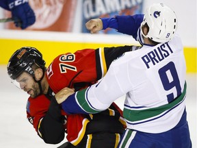Vancouver Canucks' Brandon Prust, right, fights with Calgary Flames' Blair Riley during NHL pre-season hockey action in Calgary on Friday. Shortly after, it was discovered that Riley wasn't on the game sheet and he was asked to leave by the referee.