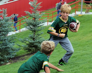 Marshall Nycz, 11, tries to keep the ball away from his borther Leopold, 8 while waiting for the game to begin as the Calgary Stampeders played host to the Edmonton Eskimos for the Labour Day Classic on September 7, 2015.