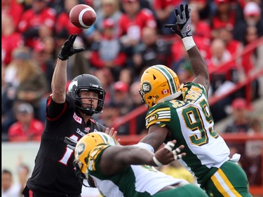 Stampeders quarterback Bo Levi Mitchell tries to get the ball away from Eskimos DT Almondo Sewell, 90, and DE Willie Jefferson, 99, as the Calgary Stampeders played host to the Edmonton Eskimos for the Labour Day Classic on September 7, 2015 at McMahon Stadium.
