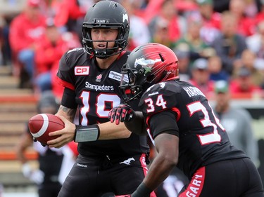 Quarterback Bo Levi Mitchell hands off to runningback Tory Harrison as the Calgary Stampeders played host to the Edmonton Eskimos for the Labour Day Classic on September 7, 2015 at McMahon Stadium.