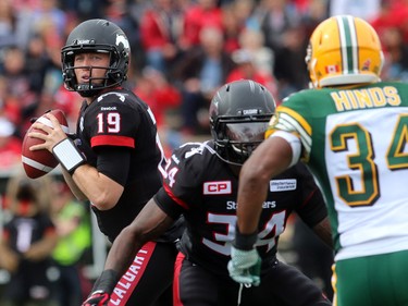 Quarterback Bo Levi Mitchell has  running back Tory Harrison holding off Eskimos safety Ryan Hinds as the Calgary Stampeders played host to the Edmonton Eskimos for the Labour Day Classic on September 7, 2015 at McMahon Stadium.