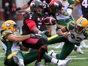 Stampeders running back Tim Brown is brought down by Eskimos  DE Mathieu Boulay, 77, and DB Otha Foster as the Calgary Stampeders played host to the Edmonton Eskimos for the Labour Day Classic on September 7, 2015 at McMahon Stadium.