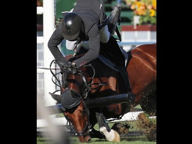 Steve Guerdat and Corbinian crash through a gate during the $210,000 Tourmaline Oil Cup at the Spruce Meadows Masters on Friday September 11, 2015. The Swiss rider and horse appeared ok.