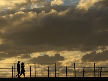 Walkers cross the George C. King Bridge to St. Patrick's Island at the end of a  fall day September 20, 2015.