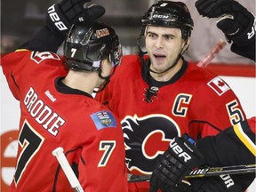 Calgary Flames Mark Giordano, centre, celebrates his goal with temates TJ Brodie, left, and Sean Monahan during second period NHL hockey action against the Arizona Coyotes in Calgary, Thursday, Nov. 13, 2014.