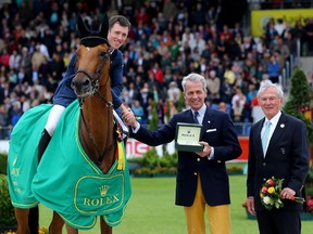 Chairman Peter Streit of Rolex Germany, centre, hands out the trophy to winner Scott Brash of Great-Britain rides on Hello Sanctos, left, with Carl Meulenbergh, president of the Aachen-Laurensberger Rennverein during the Rolex Grand Prix jumping competition of the 2015 CHIO Aachen tournament at Aachener Soers on May 31, 2015. If Brash wins the final leg of the Rolex Grand Prix at Spruce Meadows on Sunday, he will claim a $1 million Euro grand prize.