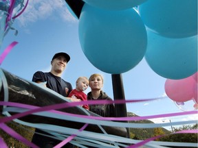 Blairmore resident Marc Ernst and fiance Katie Matthews along with their daughter Skylar Matthews, 11 months, stood by a bunch of pink and blue balloons that were tied to a railing on one of the main entry ways into downtown Blairmore on September 17, 2015. Ernst is organizing a vigil and balloon release on Friday. Community members and mourners across the country are remembering Terry Blanchette and his daughter Hailey Dunbar-Blanchette with pink and blue balloons.