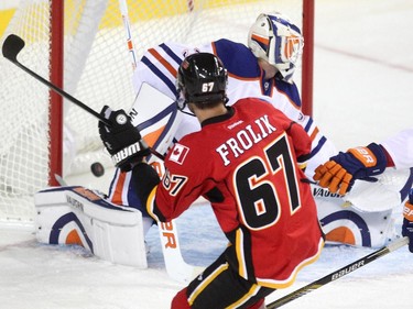 Calgary Flames right winger Michael Frolik shot the puck past Edmonton Oilers goalie Ben Scrivens during the second period of a split squad preseason NHL game at the Scotiabank Saddledome on September 21, 2015.