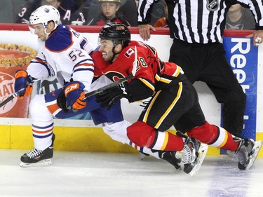 Calgary Flames right winger Emile Poirier and Edmonton Oilers centre Phil McRae got tangled up along the boards during the second period of a split squad preseason NHL game at the Scotiabank Saddledome on September 21, 2015.