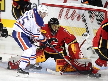 Calgary Flames goalie Jonas Hiller kept his eye on the puck as Edmonton Oilers centre Mark Letestu parked on the crease during the second period of a split squad preseason NHL game at the Scotiabank Saddledome on September 21, 2015.
