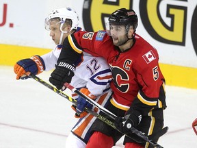 Calgary Flames defenceman Mark Giordano ties up Edmonton Oilers left winger Rob Klinkhammer during the second period of a split squad preseason game on Monday at the Scotiabank Saddledome.